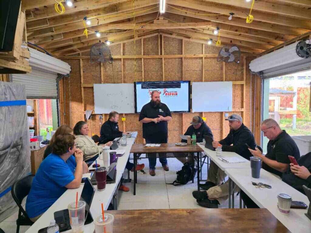 Trainer leading an on-site sales session with a team around a workshop table